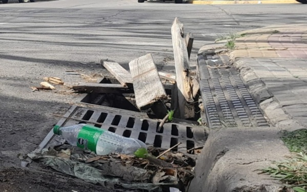 Vecinos en Plaza Malvinas reclaman por una alcantarilla que quedó expuesta y debieron tapar con maderas