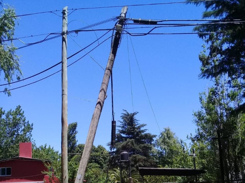 Vecinos de Villa Elisa, preocupados por un poste a punto de caerse sobre una casa hace días